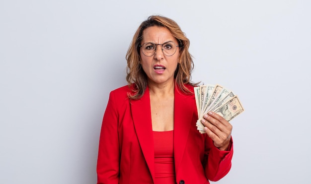 Mujer de mediana edad que se siente perpleja y confundida. concepto de billetes de dólar