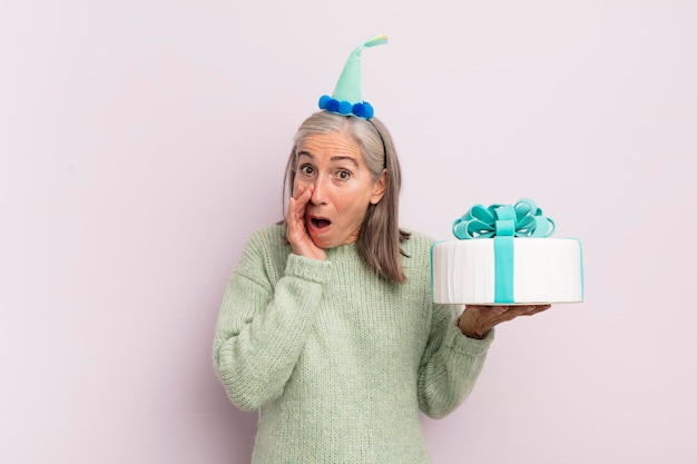 Mujer de mediana edad que se siente sorprendida y asustada concepto de pastel de cumpleaños