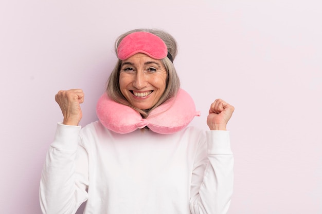 Mujer de mediana edad que se siente sorprendida, riendo y celebrando el éxito del concepto de pasajero de vuelo