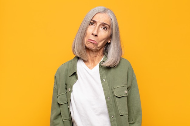 Mujer de mediana edad que se siente triste y llorona con una mirada infeliz, llorando con una actitud negativa y frustrada