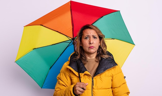 Mujer de mediana edad que se siente triste y llorona con una mirada infeliz y llorando. concepto de paraguas