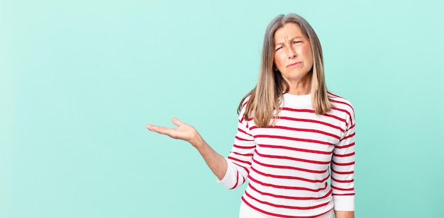 Mujer de mediana edad que se siente triste, molesta o enojada y mirando hacia un lado