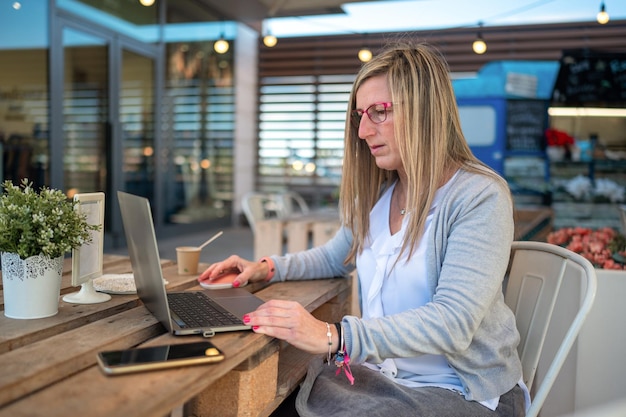 Mujer de mediana edad que trabaja en una computadora portátil