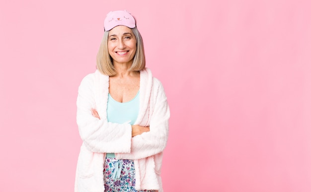 Mujer de mediana edad riendo alegremente con los brazos cruzados, con una pose relajada, positiva y satisfecha. concepto de traje de noche