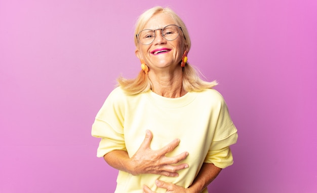 Mujer de mediana edad riendo a carcajadas de alguna broma hilarante aislada