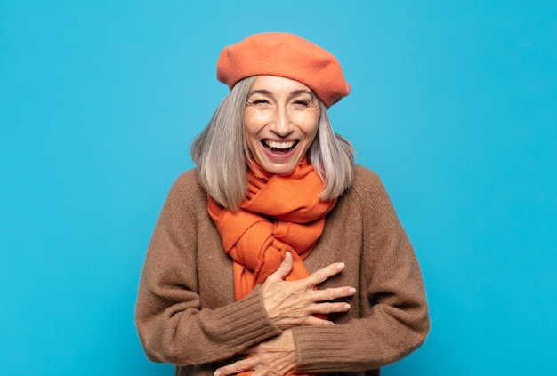 Mujer de mediana edad riendo a carcajadas de una broma hilarante