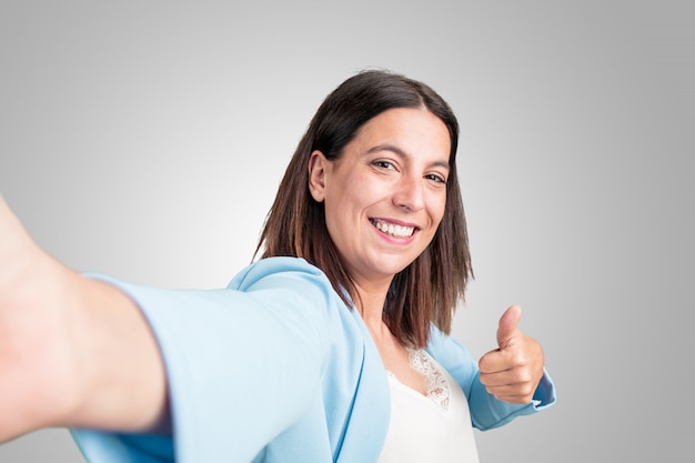 Foto mujer de mediana edad sonriendo y feliz, tomando un selfie