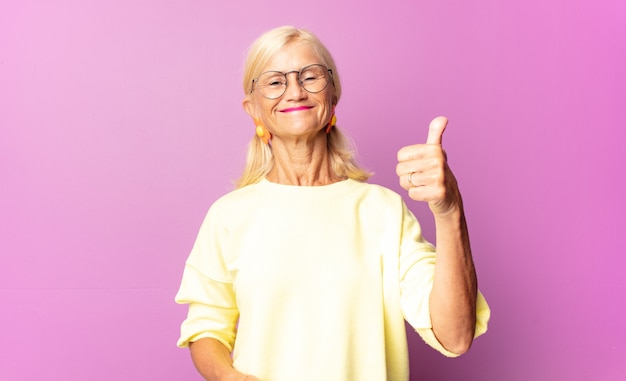 Mujer de mediana edad sonriendo y mirando amigable, mostrando el número uno