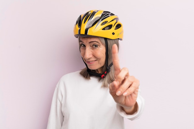 Mujer de mediana edad sonriendo con orgullo y confianza haciendo el concepto de casco de bicicleta número uno