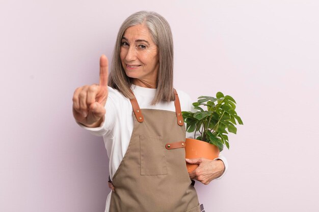 Mujer de mediana edad sonriendo con orgullo y confianza haciendo el concepto de granjero número uno