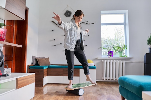 Mujer de mediana edad en el tablero de equilibrio de fitness