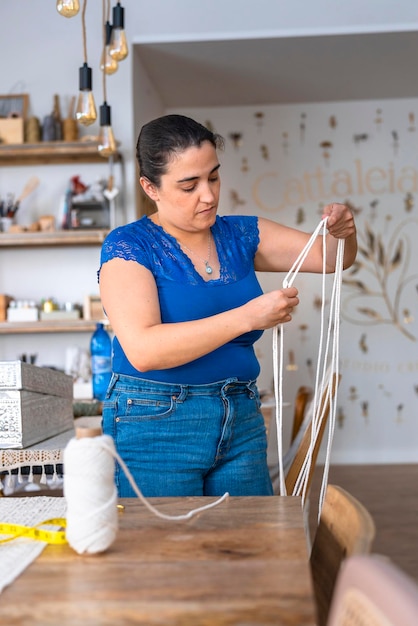 Mujer de mediana edad trabaja en un taller de costura.