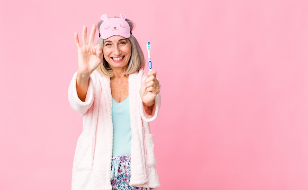 Mujer de mediana edad con traje de noche con un cepillo de dientes