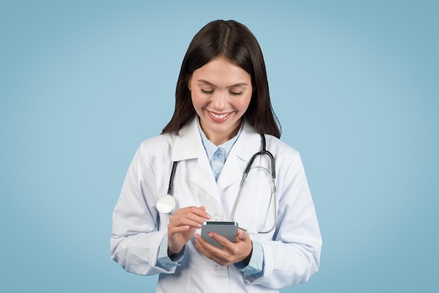Mujer médica felizmente usando el teléfono inteligente salud digital