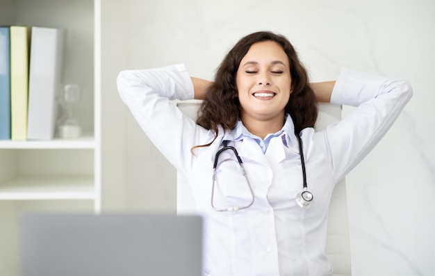 Foto una mujer médica relajada respira profundamente mientras trabaja en la clínica.