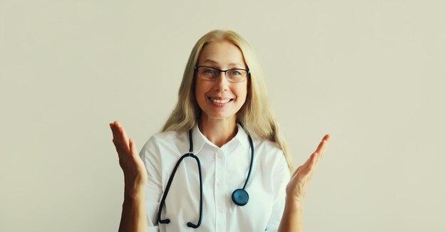 mujer médico mirando a la cámara hablando en llamada de video sentada en el escritorio en la oficina de la clínica