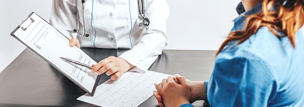 Mujer en el médico en la recepción para comprobar la salud en la mesa sobre fondo blanco aislado