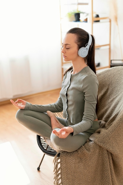 Foto mujer meditando en casa en silla