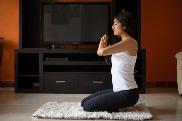 Mujer meditando en casa