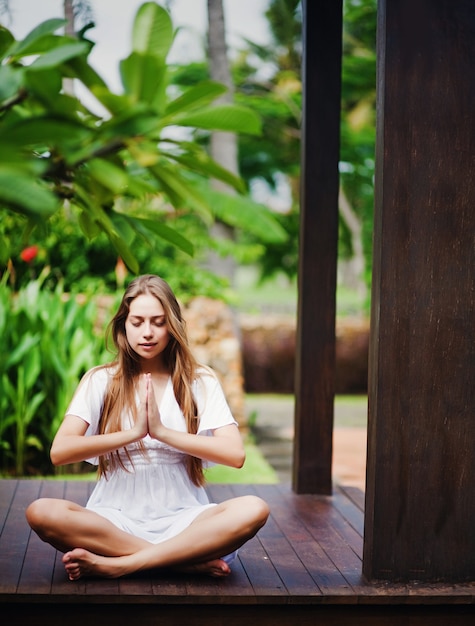 Mujer meditando en un jardín tropical en una glorieta
