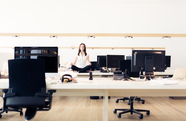 Foto mujer meditando en la mesa en la oficina