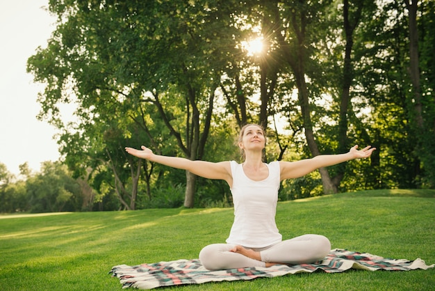 Mujer meditando en el parque de la ciudad