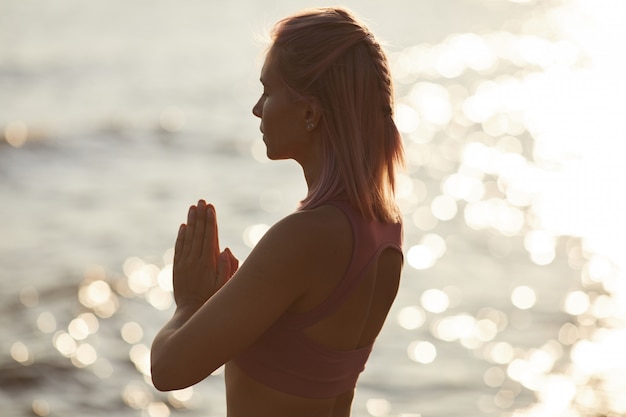 Mujer meditando en la playa