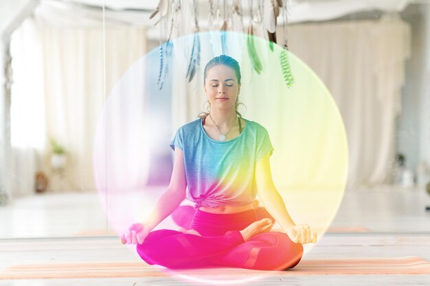 Foto mujer meditando en la postura del loto en el estudio de yoga