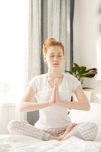 Mujer meditando sobre la cama