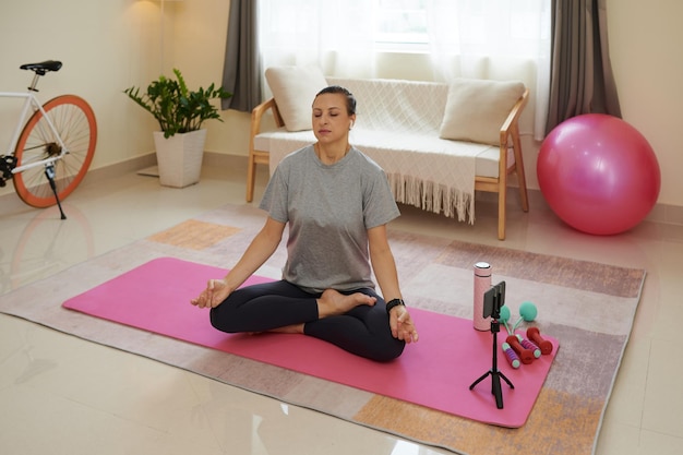 Mujer meditando sobre estera de yoga