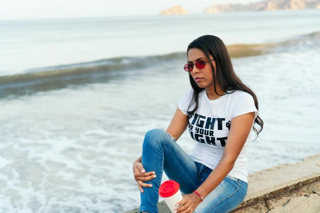 Mujer con un mensaje feminista en su camiseta sosteniendo una taza de café