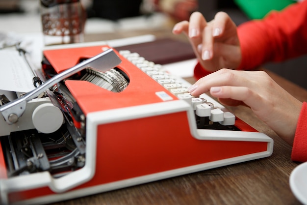 Mujer en la mesa escribiendo en máquina de escribir