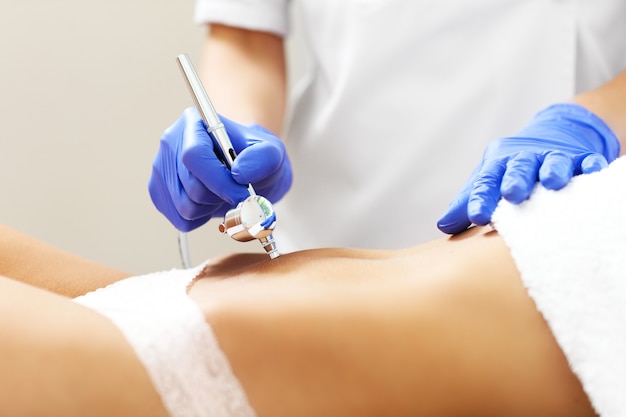 Mujer con mesoterapia de abdomen en salón de belleza