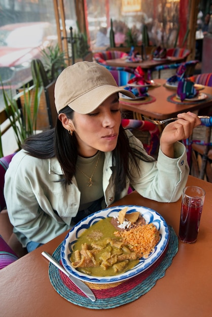 Foto mujer mexicana de tiro medio comiendo comida ranchera