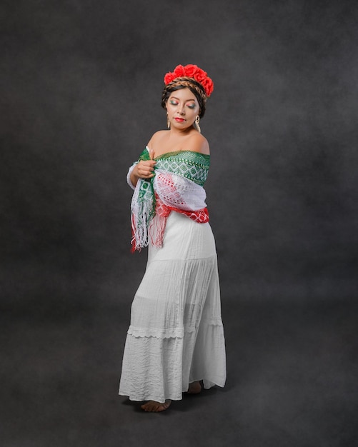 Mujer mexicana con vestido blanco y bufanda con los colores de la bandera mexicana