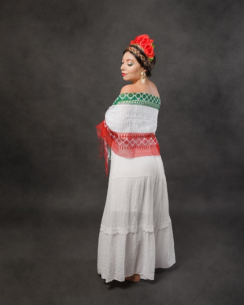 Mujer mexicana con vestido blanco y bufanda con los colores de la bandera mexicana