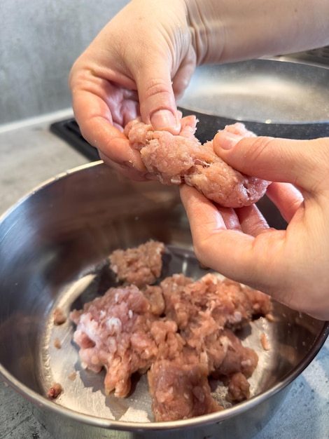 Mujer mezclando a mano carne picada en un cuenco en un primer plano de la cocina