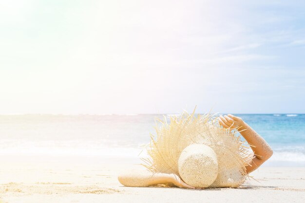 La mujer miente en la arena blanca en la playa