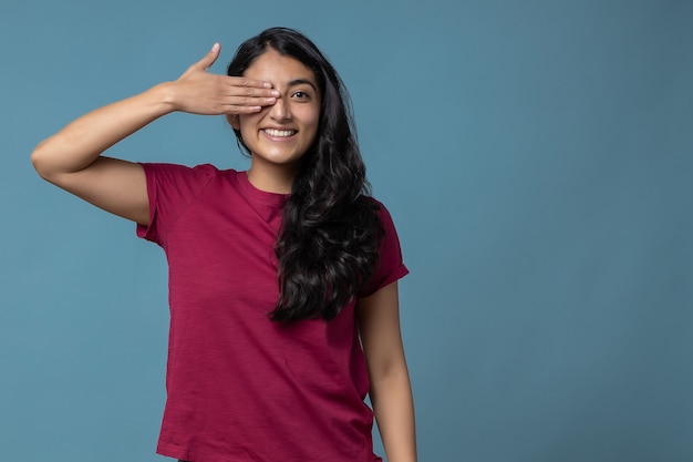 Mujer milenaria latina mexicana cubriendo un ojo y sonriendo