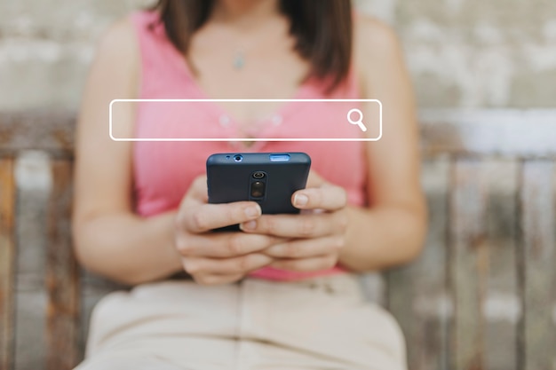 Foto mujer milenaria usando el teléfono para encontrar información en línea en el navegador móvil