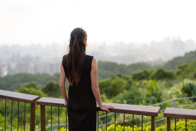 Mujer mira la ciudad en la montaña