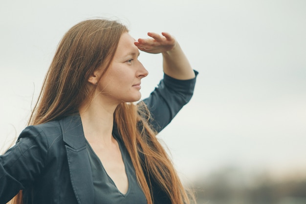 La mujer mira a lo lejos. El concepto de manifestaciones de las emociones, problemas de visión.