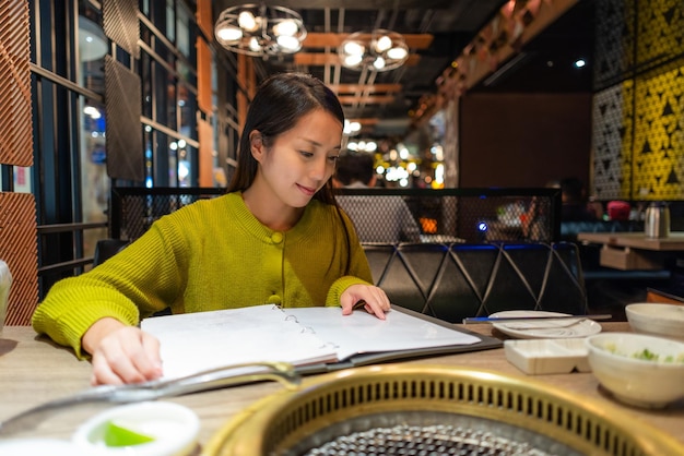 Mujer mira el menú del restaurante