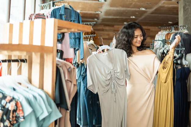 Mujer mirando algo de ropa en la tienda de moda