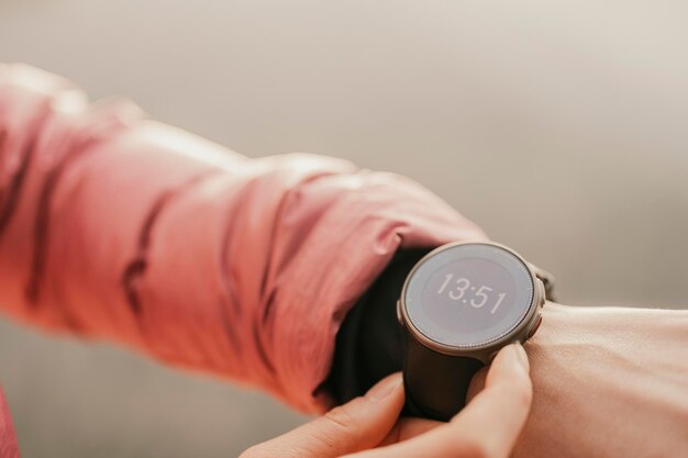 Mujer mirando la aplicación en sportwatch Runner con monitor de frecuencia cardíaca reloj deportivo inteligente Comprobación de la posición GPS de rendimiento o pulso de frecuencia cardíaca