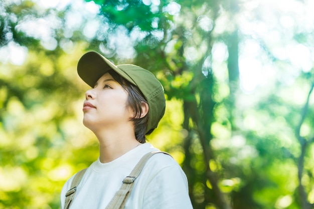 Mujer mirando hacia los árboles en el bosque en buen día