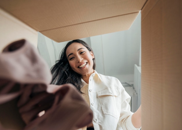 Foto mujer mirando una caja con ropa