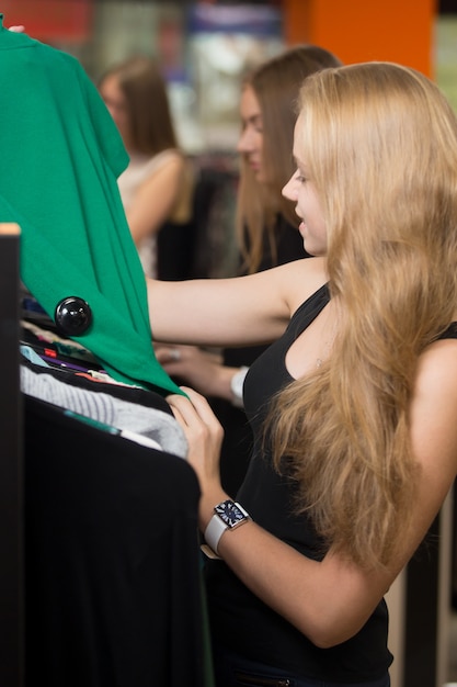 Mujer mirando una camiseta verde