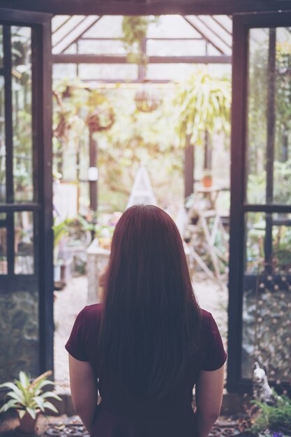 mujer mirando a la casa de cristal