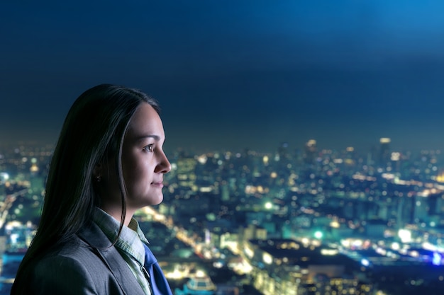 Mujer mirando a la ciudad de noche